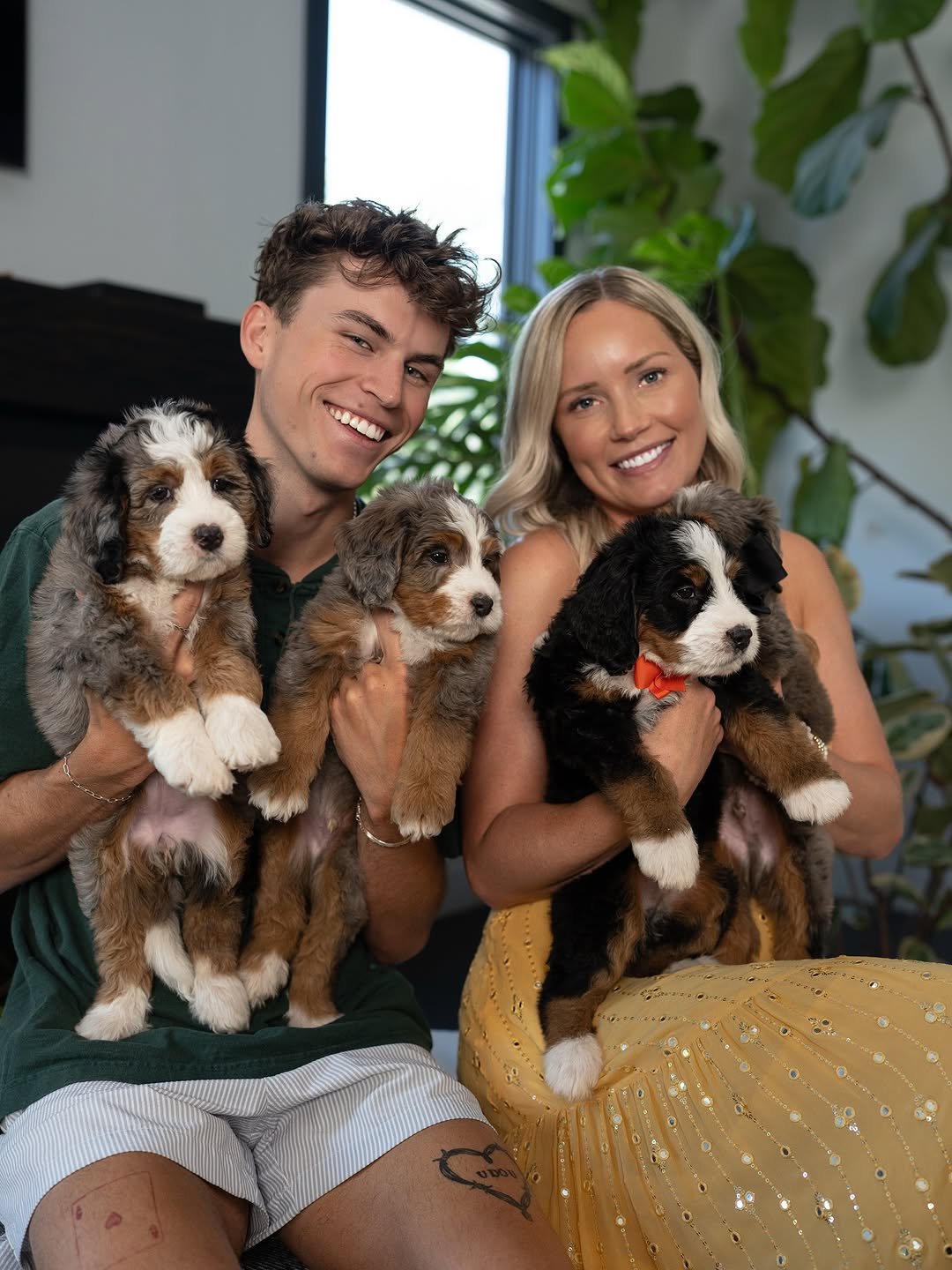 Furry Friends HQ team holding two doodle puppies at their Greenville home